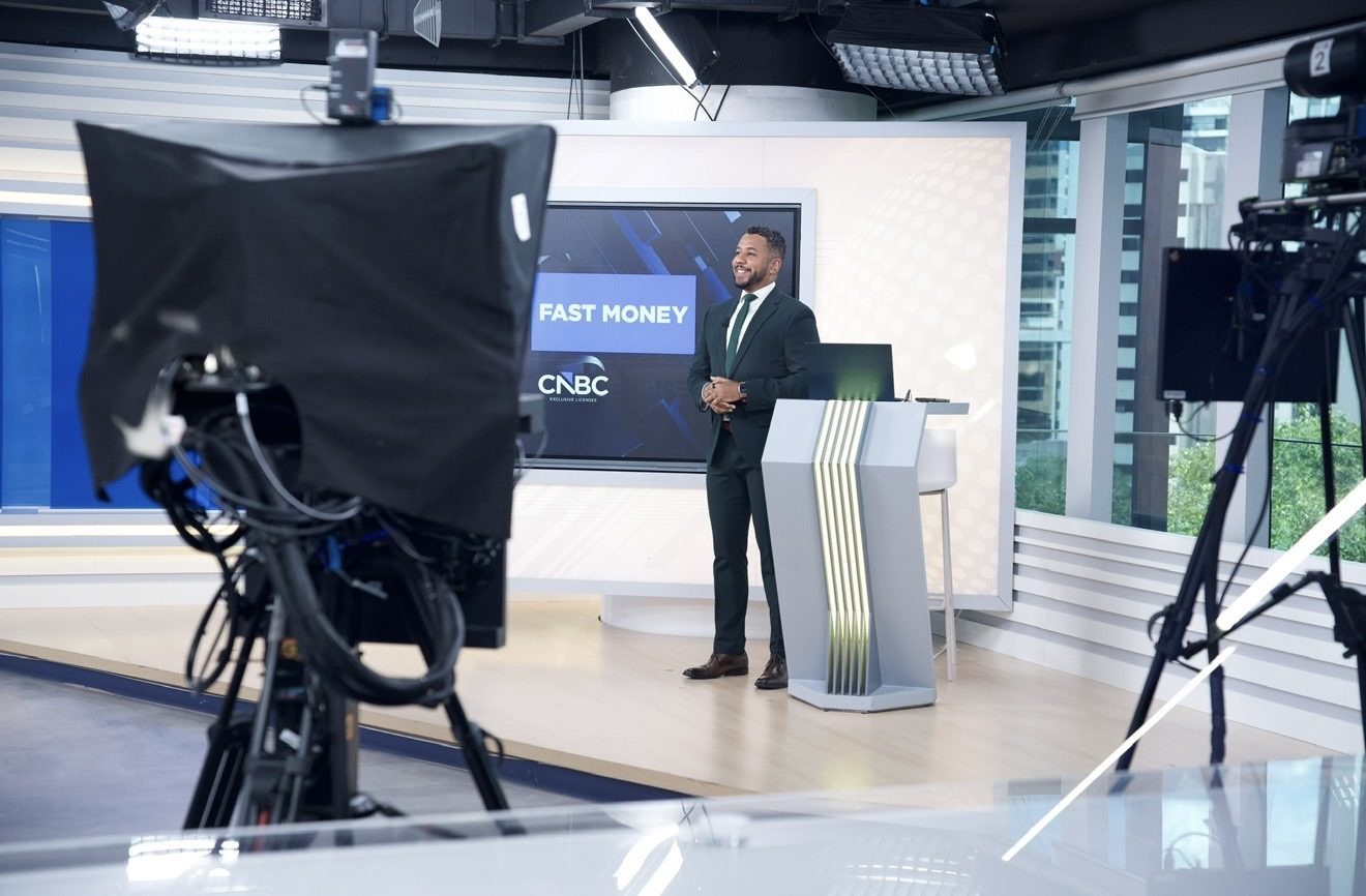 Renan de Souza de braços cruzados na redação da CNBC